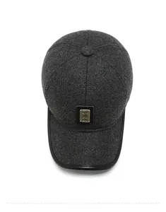 Top view of dark grey wool baseball cap with metal plaque and leather trim edge