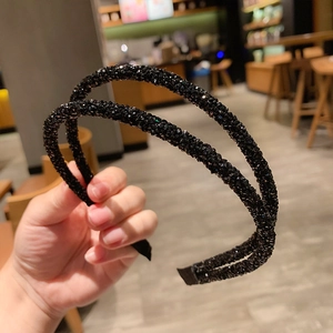 Close-up of black double-layered headband with sparkling crystals and sleek finish