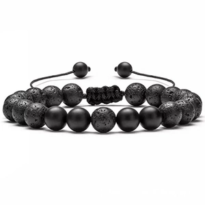 Macro detail of braided adjustable bracelet with porous lava rock and matte black beads