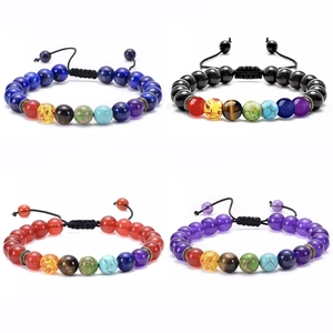 Detail of four adjustable chakra bracelets with colorful natural stones and woven cord
