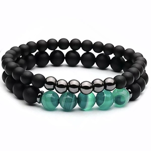 Macro detail of matte black onyx and green striped agate beads in two-piece bracelet set
