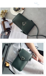 Détail du sac de téléphone vert vintage avec boucle en cœur doré et bandoulière fine