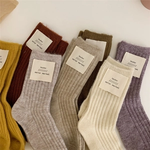 Detailed close-up of colorful thick wool knit crew socks with ribbed texture and tags