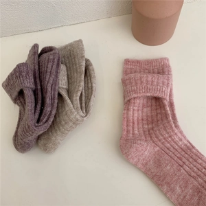 Flat lay view of folded pink and purple thick wool blend thermal socks for women