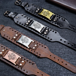 Detailed view of Viking wide leather bracelets with Celtic knot metal charms and rivets