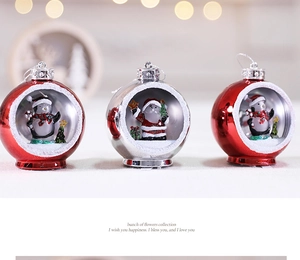 Detail of Christmas glowing ornament ball with miniature penguin and Santa Claus inside