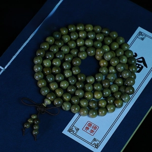 Détail macro de 108 perles en bois de Vera d'Argentine sur boîte cadeau bleue avec nœuds