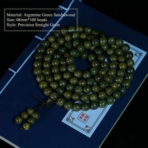 Détail de perles de santal vert de 8mm avec gravures Bouddha sur un livre ancien