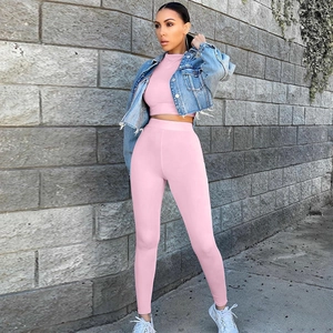 Λεπτομέρεια από ροζ crop top και κολάν με ψηλή μέση σε φόντο από τούβλα εξωτερικά