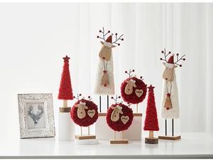 Close-up of Nordic wool felt reindeer and wooden Christmas tree desktop decorations