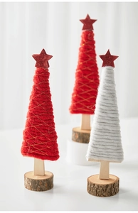 Close-up of wool-wrapped Christmas tree ornaments with wooden bases and glitter stars