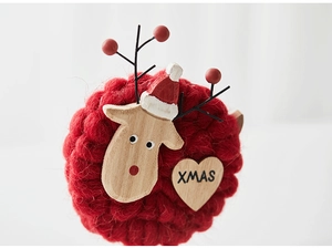 Macro detail of Nordic Christmas felt deer ornament with wooden heart and XMAS lettering