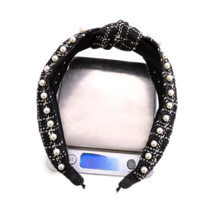 Detail showing the 49.63g weight of the black and white tweed pearl headband on a scale