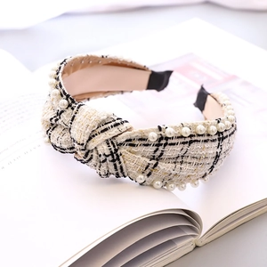 Detailansicht eines Tweed-Haarreifens mit weißen Perlen und zentralem Knoten-Design