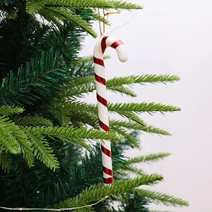 Classic red and white striped candy cane Christmas ornaments hanging on a green Xmas tree