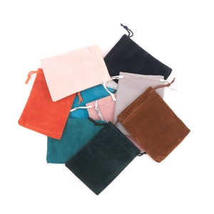 Detailed overhead view of assorted velvet drawstring jewelry pouches in multiple vibrant colors
