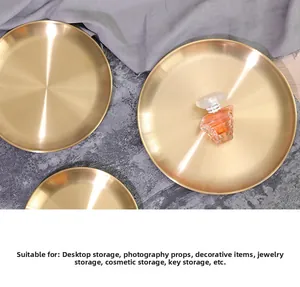 Detail showing various sizes of brushed gold metal trays with minimalist perfume bottles