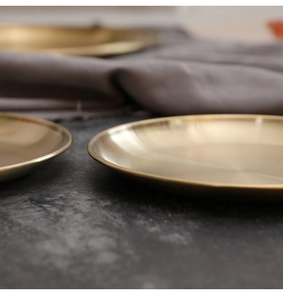 Macro detail showing brushed gold stainless steel surface and rounded edges of the tray