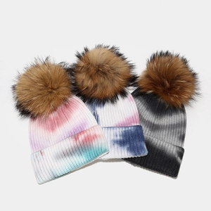 Women's winter tie-dye knitted beanie hat with fluffy raccoon fur pompom in vibrant colors