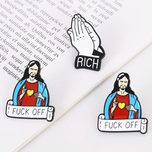 Broches en émail représentant Jésus et des mains de prière sur un fond de livre