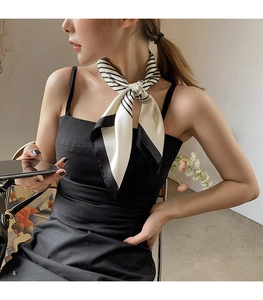 Detail of silk-satin scarf with black and white stripes tied elegantly on a model's neck