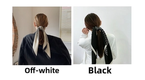 Detail of black and cream striped silk scarves showing smooth texture and contrast colors