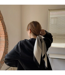 Fashionable black and white striped silk scarf used as a stylish hair tie for women