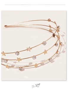 Detail of a triple-layer gold star headband with rhinestones and celestial accents