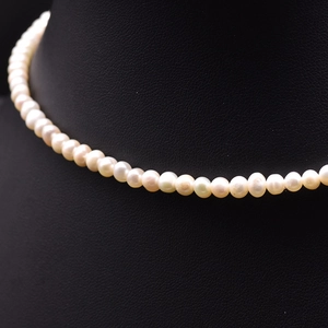 Elegant natural freshwater pearl necklace with high luster on a black neck display stand