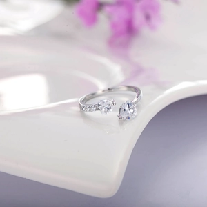 Macro detail of silver open ring with heart and pear-shaped cubic zirconia stones
