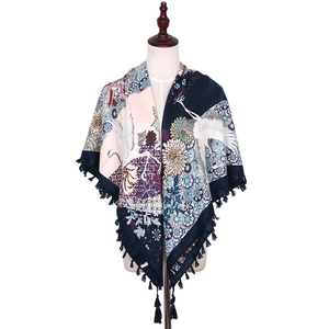Detail of bohemian scarf with crane and floral pattern featuring knotted fringe edges