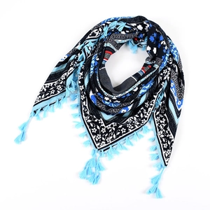 Detail of bohemian triangle scarf with blue and black patterns and decorative fringes