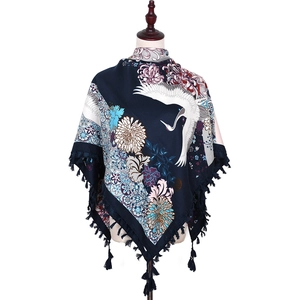 Detail of bohemian scarf with crane floral embroidery and dark blue fringe tassels