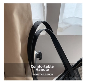 Gros plan sur les doubles poignées et la texture rayée du sac bandoulière noir