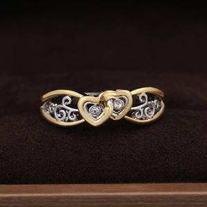 Interlocked two-tone heart ring with sparkling crystals and elegant scrollwork detailing
