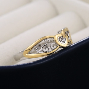 Minimalist silver and gold heart ring with filigree patterns and zircon crystals