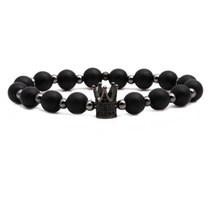 Bracciale corona in pietre nere opache con ciondoli micro-pave su sfondo bianco