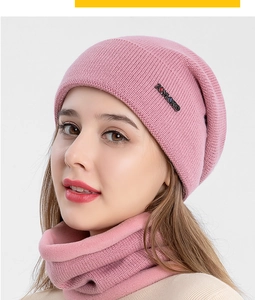 Détail d'un ensemble bonnet tricoté rose et cache-col doublé polaire avec logo