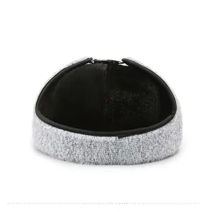 Detail view of winter hat with grey knit exterior and thick black faux fur lining