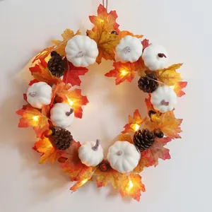 Fall wreath with maple leaves white pumpkins pine cones and LED lights for Halloween