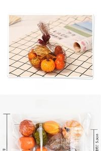 Detail of autumn decor set with mini pumpkins and maple leaves in a net bag