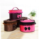 Cylindrical cosmetic bags with polka dots and bow detailing on a wooden floor