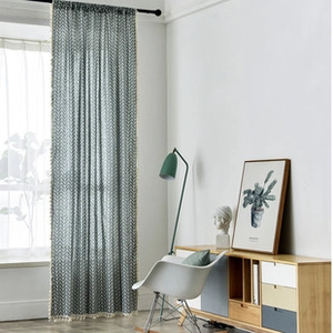 Close-up of geometric wave patterns and pom-pom tassel trim on cotton linen curtains