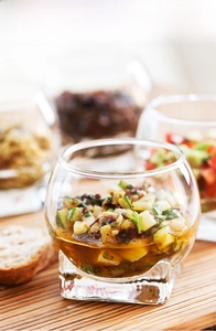 Close-up of creative round glass pudding cup with thick square base for desserts