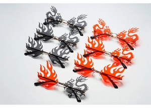 Flat lay of rimless sunglasses in flame and dragon shapes with gold metal frames