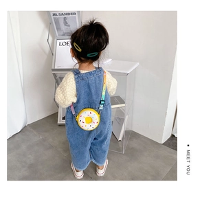 Enfant portant un sac bandoulière donut en silicone jaune avec sangle arc-en-ciel