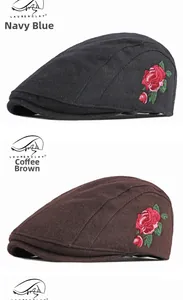Détail de bérets en laine bleu marine et marron avec broderie de rose vintage