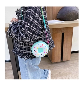 Fillette portant un sac bandoulière en silicone en forme de donut vert menthe