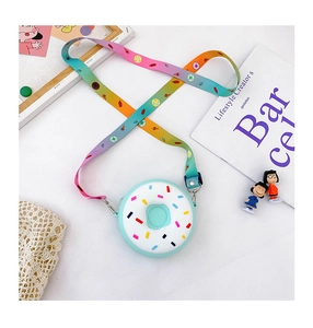 Détail du sac donut vert menthe avec décor de glaçage blanc et bandoulière arc-en-ciel
