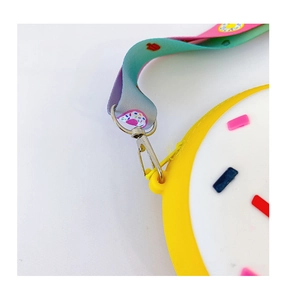 Détail macro du porte-monnaie donut en silicone avec bandoulière arc-en-ciel dégradée